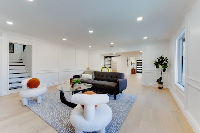 living room featuring ornamental molding and light hardwood / wood-style flooring