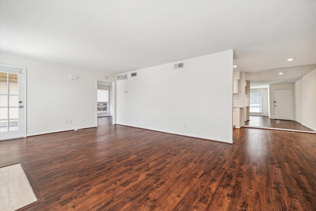 unfurnished living room with dark wood-type flooring