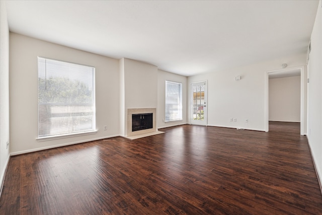 unfurnished living room with plenty of natural light and dark wood-type flooring