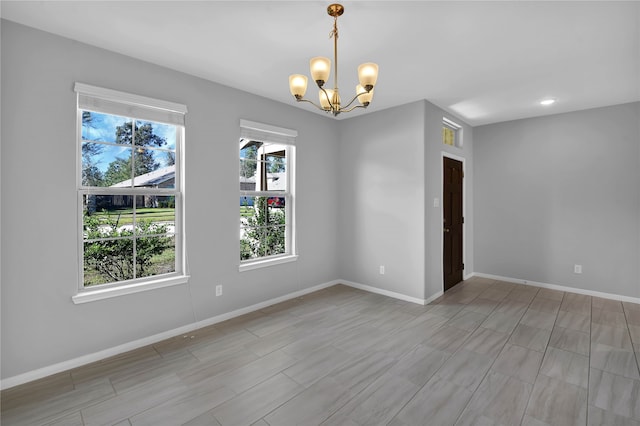 unfurnished room featuring an inviting chandelier