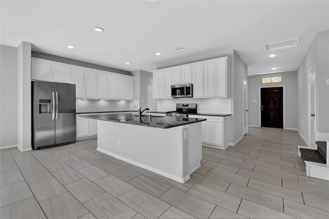 kitchen with white cabinetry, an island with sink, and stainless steel appliances