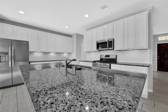 kitchen with stainless steel appliances, white cabinetry, and sink