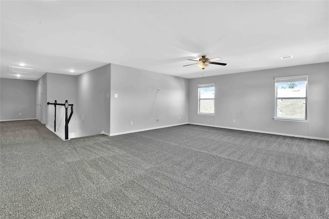 carpeted spare room featuring a wealth of natural light and ceiling fan