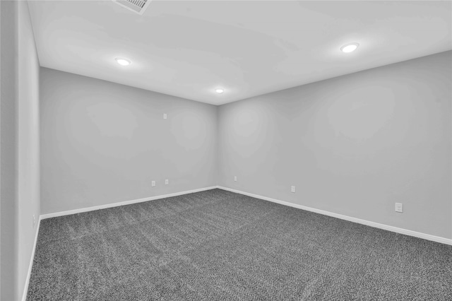 spare room featuring dark carpet