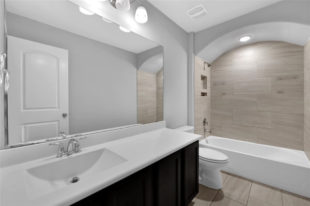 full bathroom featuring toilet, vanity, and tiled shower / bath