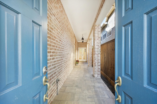 interior space with beam ceiling and brick wall