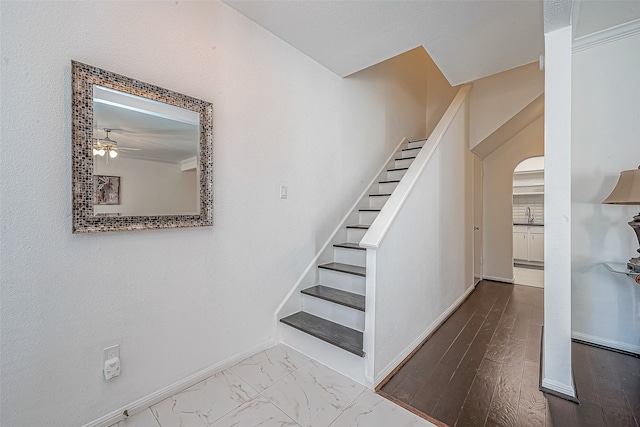 stairway with crown molding and sink