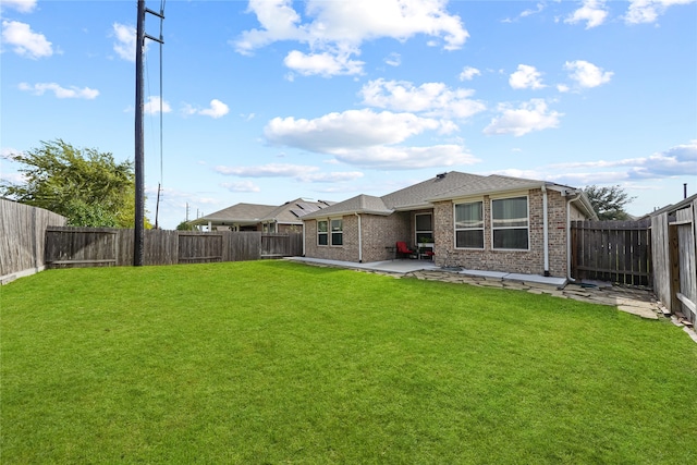 rear view of house with a lawn and a patio area