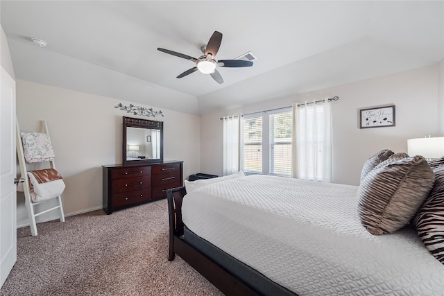 carpeted bedroom featuring ceiling fan and a raised ceiling