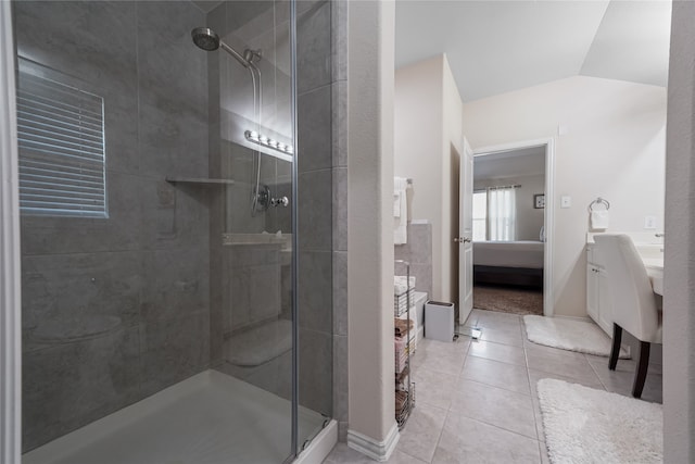 bathroom with tile patterned flooring, lofted ceiling, and a shower with door