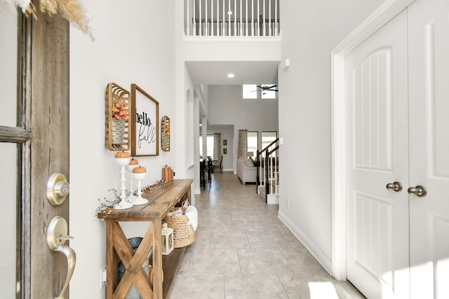 tiled foyer featuring a high ceiling and ceiling fan