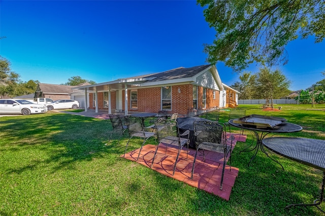 rear view of house featuring a patio area and a yard