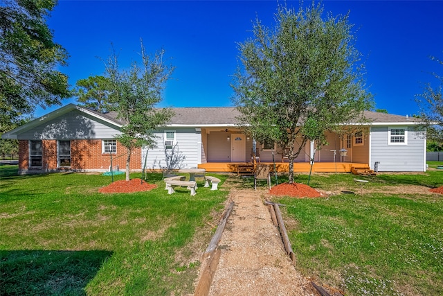 rear view of property with covered porch and a yard