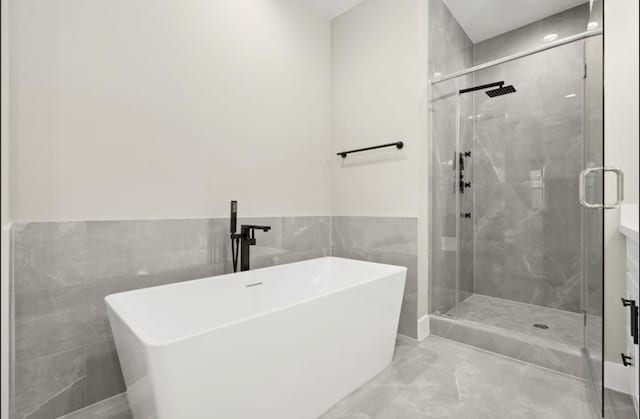 bathroom with vanity, independent shower and bath, and tile walls