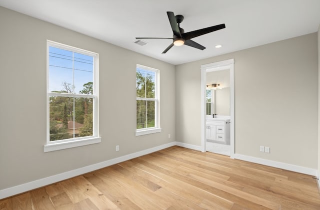 unfurnished bedroom with light wood-type flooring, connected bathroom, and ceiling fan