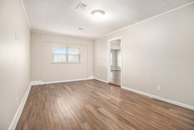 spare room featuring hardwood / wood-style flooring, ceiling fan, and ornamental molding