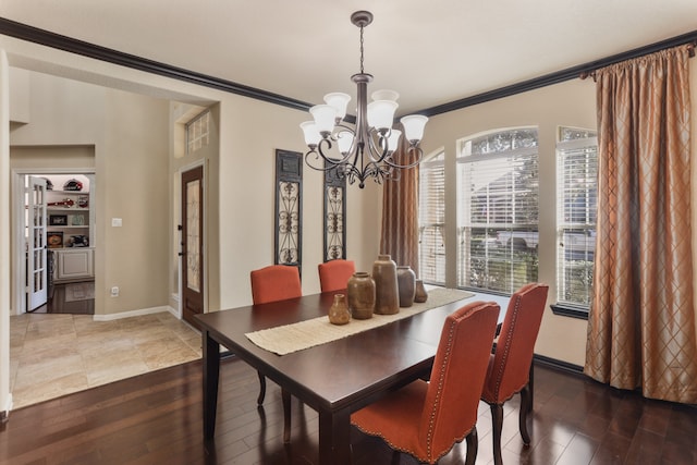 dining room featuring dark hardwood / wood-style flooring, an inviting chandelier, and crown molding