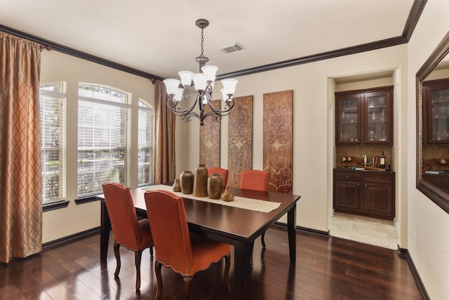 dining room with sink, a notable chandelier, dark hardwood / wood-style flooring, and crown molding