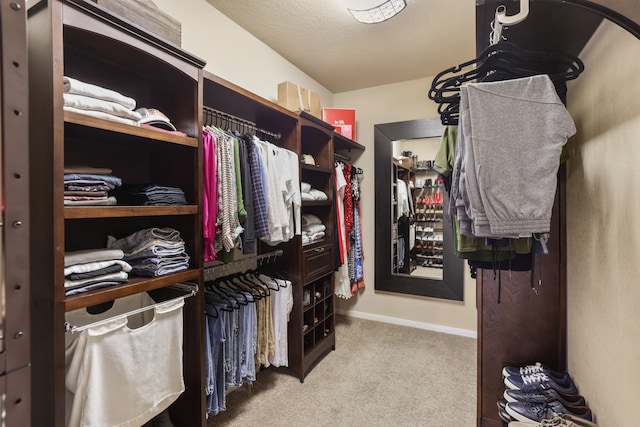 walk in closet featuring light colored carpet