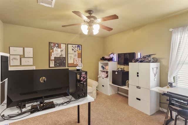 carpeted home office featuring ceiling fan