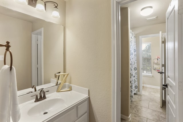 bathroom featuring tile patterned floors, vanity, and a textured ceiling