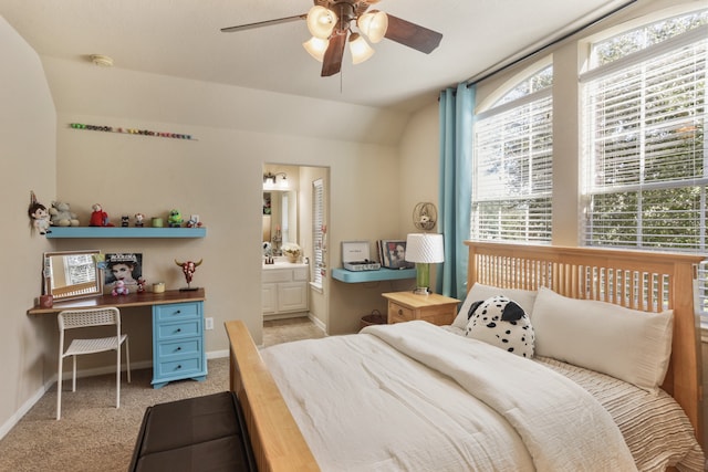 bedroom featuring ensuite bathroom, ceiling fan, light carpet, and vaulted ceiling