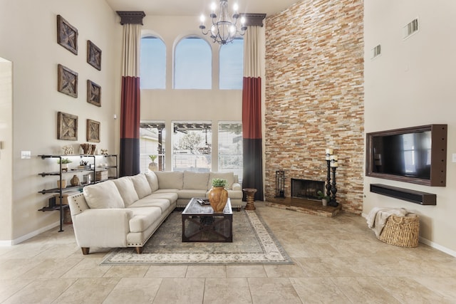 living room featuring a fireplace, a towering ceiling, and a chandelier