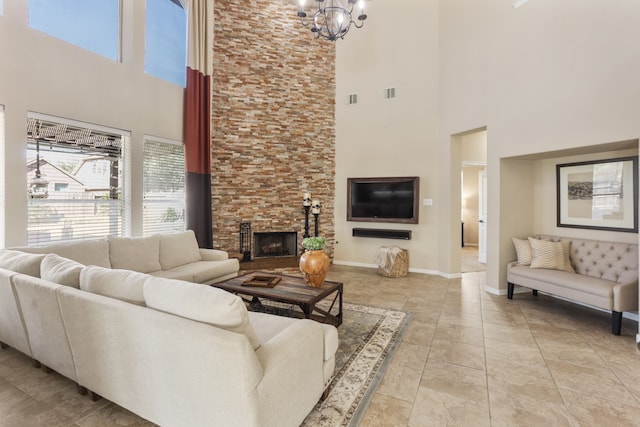 living room with a fireplace, a towering ceiling, and a chandelier