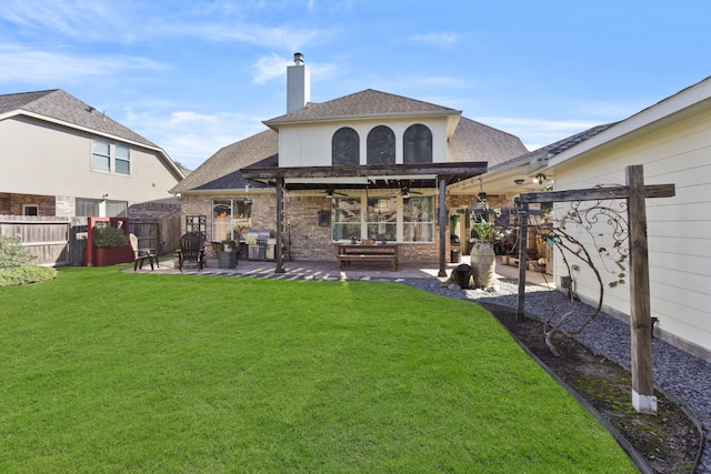 back of property with ceiling fan, a patio area, and a yard