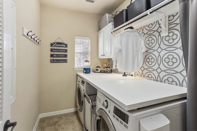 washroom with cabinets and washing machine and clothes dryer