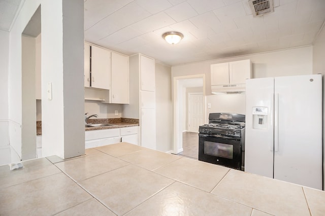 kitchen with black gas range, white fridge with ice dispenser, sink, light tile patterned floors, and white cabinets