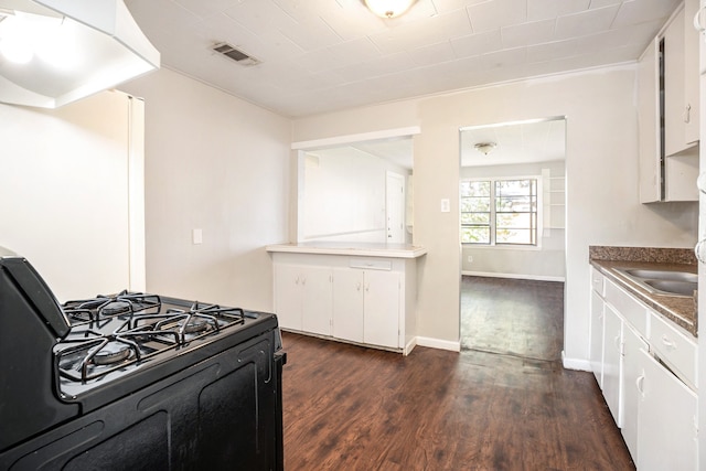 kitchen featuring dark hardwood / wood-style floors, gas stove, white cabinetry, and sink