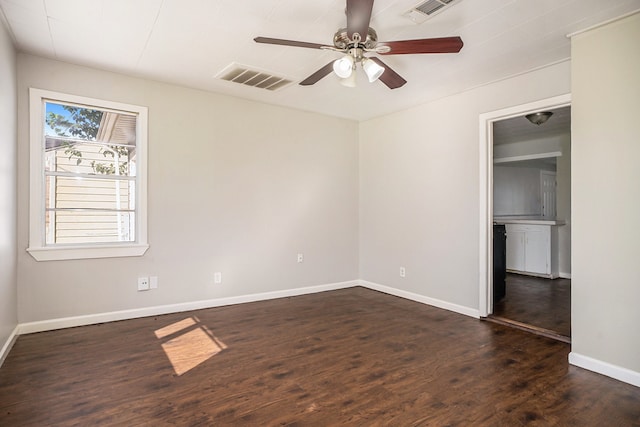 spare room featuring ceiling fan and dark hardwood / wood-style floors