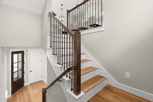 stairway featuring hardwood / wood-style flooring and vaulted ceiling