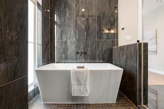 bathroom featuring tile patterned flooring, a healthy amount of sunlight, and tile walls