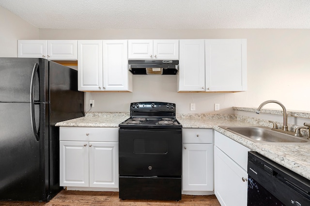 kitchen featuring sink, hardwood / wood-style flooring, white cabinetry, and black appliances