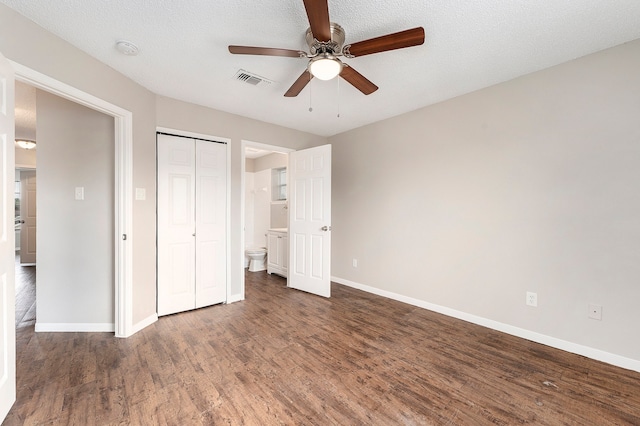 unfurnished bedroom with a textured ceiling, a closet, ceiling fan, and dark wood-type flooring