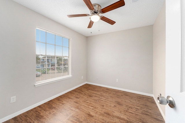 spare room featuring a textured ceiling, hardwood / wood-style flooring, and plenty of natural light