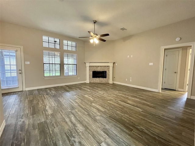 unfurnished living room featuring a wealth of natural light, ceiling fan, and dark hardwood / wood-style floors