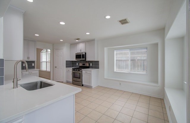 kitchen with decorative backsplash, appliances with stainless steel finishes, plenty of natural light, and sink