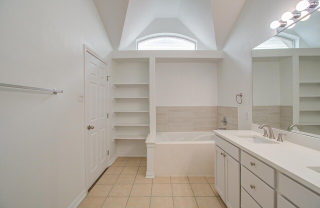 bathroom with a bath, tile patterned floors, vanity, and vaulted ceiling