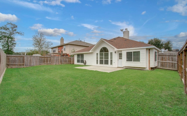 back of house with a patio area and a lawn