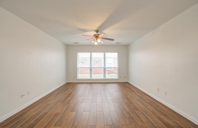 unfurnished room with ceiling fan and dark hardwood / wood-style flooring