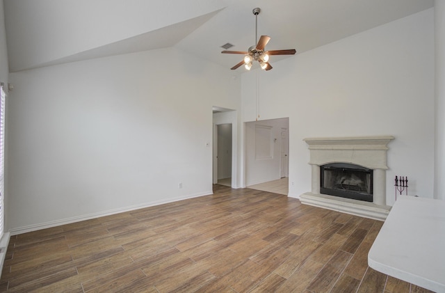 unfurnished living room featuring hardwood / wood-style floors, ceiling fan, and high vaulted ceiling