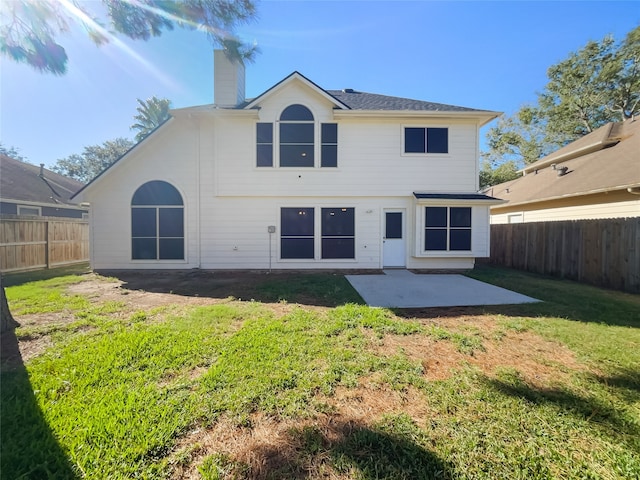 rear view of property with a yard and a patio