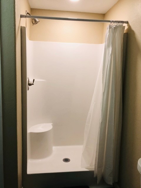 bathroom featuring a shower with shower curtain and toilet