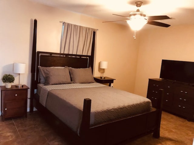 tiled bedroom featuring ceiling fan