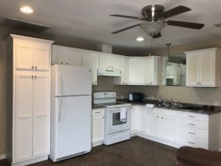 kitchen with white cabinets, white appliances, ceiling fan, and sink