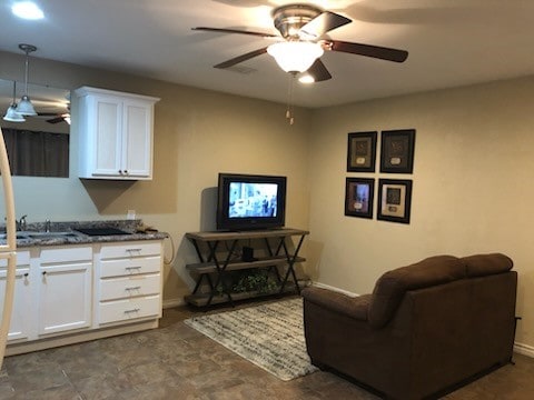 living room with ceiling fan and sink