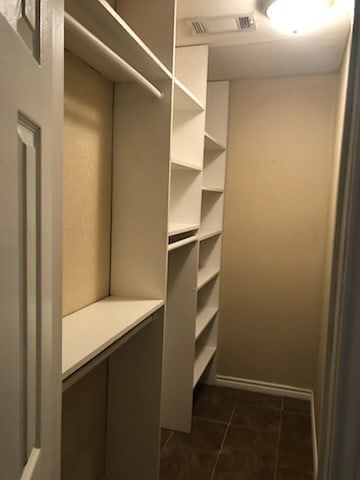 walk in closet featuring dark tile patterned floors